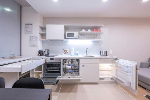 a kitchen with white cabinets and an open dishwasher at Luxury Suites Liechtenstein in Vienna