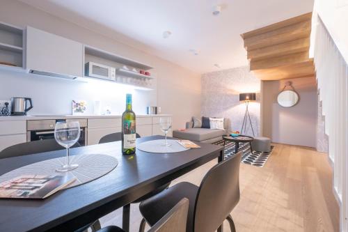 a kitchen and living room with a table with wine glasses at Luxury Suites Liechtenstein in Vienna