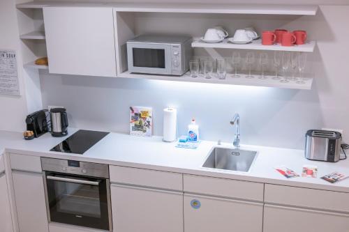 a kitchen with a sink and a microwave at Luxury Suites Liechtenstein in Vienna