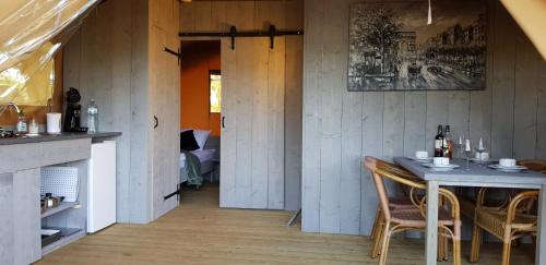 une salle à manger avec une table et des chaises dans une pièce dans l'établissement Glamping Les Arbres, Luxe Safaritent met zwembad, à Cronat