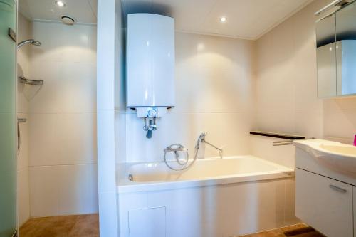 ein Badezimmer mit einem Waschbecken und einer Badewanne in der Unterkunft Appartementencomplex Juliana 122 in De Koog