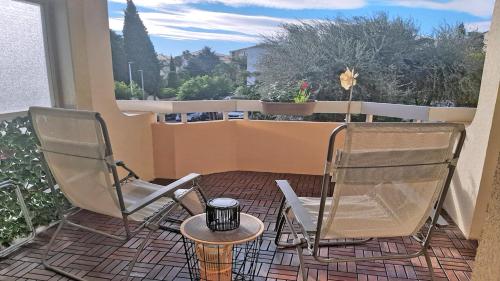 zwei Stühle und ein Tisch auf einem Balkon in der Unterkunft Patio Fleuri in Sainte-Maxime