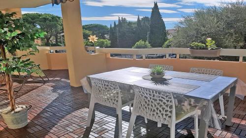 ein weißer Tisch und Stühle auf einer Terrasse in der Unterkunft Patio Fleuri in Sainte-Maxime