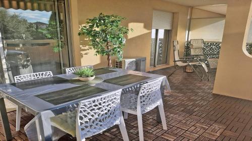 Ein Tisch und Stühle in einem Wohnzimmer mit einer Pflanze in der Unterkunft Patio Fleuri in Sainte-Maxime