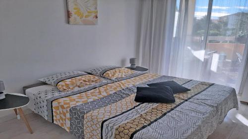 łóżko w pokoju z oknem i łóżko sidx sidx sidx w obiekcie Patio Fleuri w miejscowości Sainte-Maxime