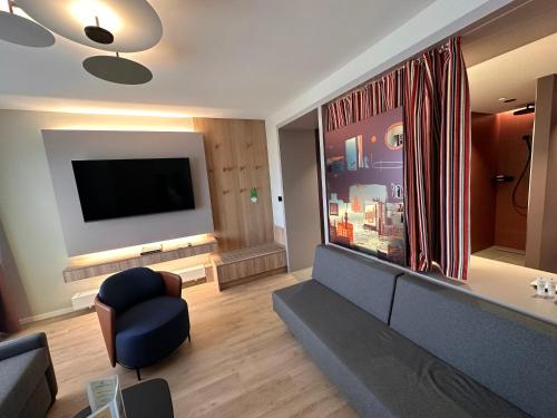 a living room with a couch and a flat screen tv at Apartment-Hotel Hamburg Mitte in Hamburg