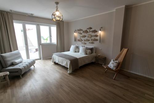 a bedroom with a bed and a chair and a couch at Love & Fama Hotel in Sabaudia