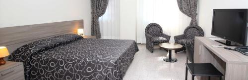 a hotel room with a bed and a flat screen tv at Hotel Croce Di Malta in Novara