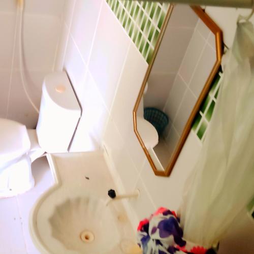 a bathroom with a toilet and a mirror at Chalés Mariza in Luis Correia