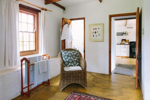 a living room with a wicker chair and a window at Beaumont Family Wines in Botrivier