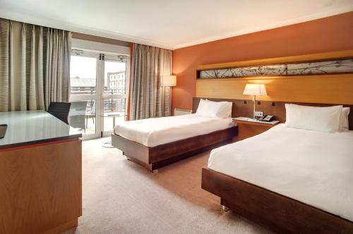 a hotel room with two beds and a desk at Best Western Plus The Quays Hotel Sheffield in Sheffield