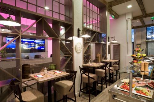 a restaurant with tables and chairs in a room at Estilo Fashion Hotel Budapest in Budapest