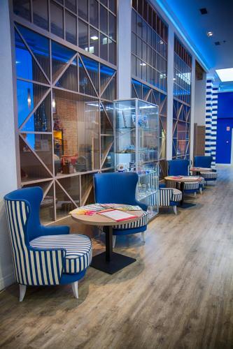 a waiting room with blue chairs and a table at Estilo Fashion Hotel Budapest in Budapest