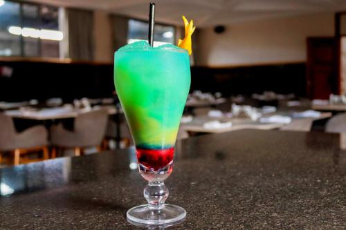 a green drink in a glass sitting on a table at Blooming Suites in Naivasha