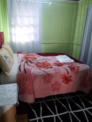 a bedroom with a bed with a pink blanket at pousada alternativa dora in Urubici