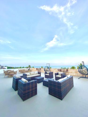 a group of blue couches on a patio with the ocean at Nobile Suítes Tambaú in João Pessoa