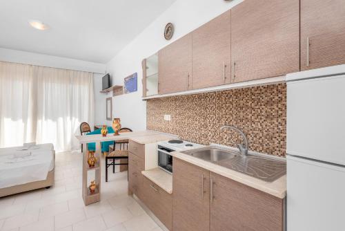 a kitchen with wooden cabinets and a sink in it at Paradise Garden in Kolimbia