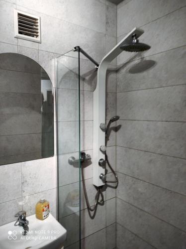 a shower with a glass door next to a sink at Studio z Widokiem in Skarżysko-Kamienna