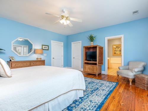 um quarto azul com uma cama e uma televisão em 5 Oclock Somewhere em Tybee Island