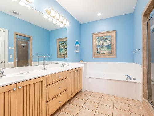 uma casa de banho azul com uma banheira, um lavatório e uma banheira em 5 Oclock Somewhere em Tybee Island