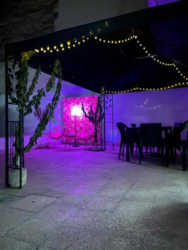 a tent with a table and chairs and purple lights at L’angolo rosa in Carosino
