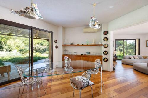un salon avec une table en verre et des chaises dans l'établissement Villa in Gated Community of Hotel La Réserve, à Ramatuelle