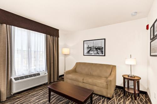 a hotel room with a couch and a window at Cobblestone Hotel & Suites - Superior Duluth in Superior