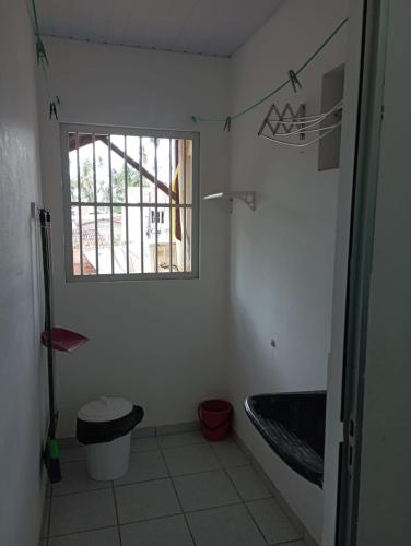 a bathroom with a tub and a sink and a window at Condominio Oliveira in Maragogi