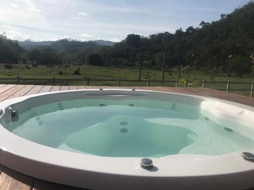 a jacuzzi tub on a deck with a view at Espaço Casa na Rocha in São José dos Campos