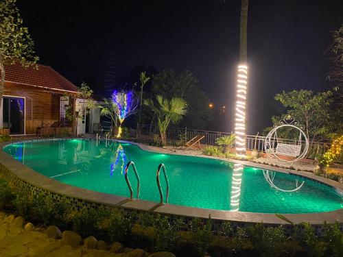 a swimming pool at night with lights on it at D&D riverside Homestay in Xuân Sơn