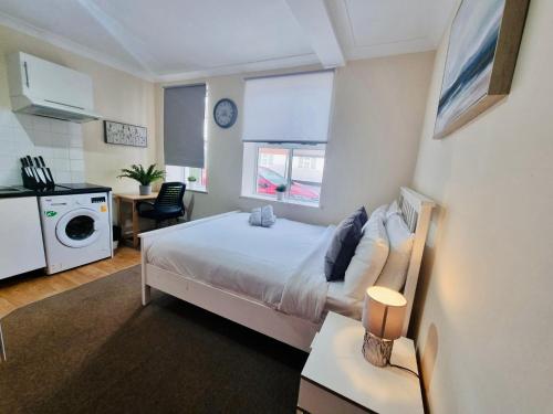 a small bedroom with a bed and a kitchen at Midewell Court by Kasar Stays in Otford