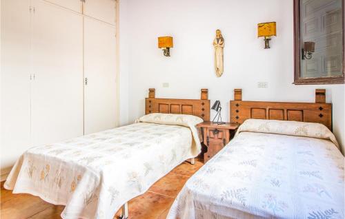 a bedroom with two beds and a cross on the wall at Pet Friendly Apartment In Playa Honda With Kitchen in Playa Honda