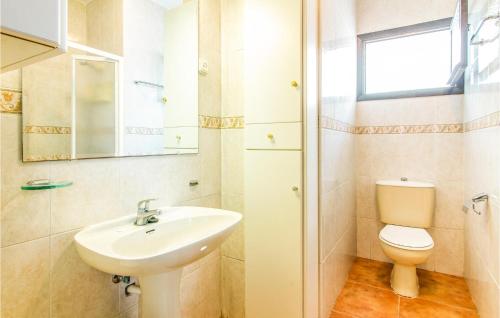 a bathroom with a sink and a toilet and a mirror at Pet Friendly Apartment In Playa Honda With Kitchen in Playa Honda
