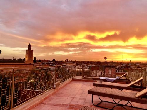 balcón con banco y puesta de sol en Riad Home Zemrane, en Marrakech
