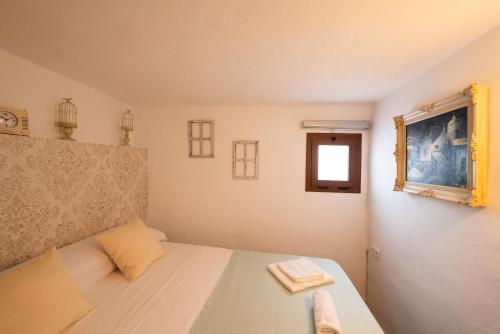 ein kleines Schlafzimmer mit einem Bett und einem Fenster in der Unterkunft Apartamento Andalucía in Cómpeta