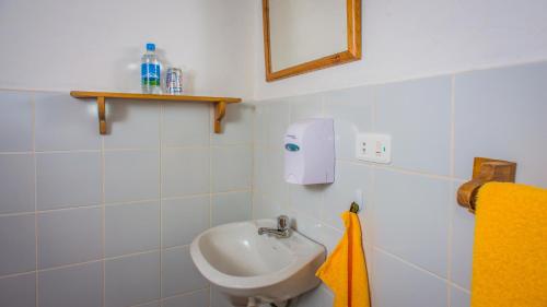 a white bathroom with a sink and a mirror at Hosteria La Terraza in Puerto López