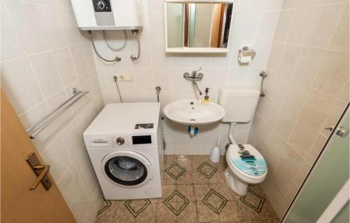 ein kleines Bad mit einer Waschmaschine und einem Waschbecken in der Unterkunft Amazing Home In Susak With Kitchen in Susak