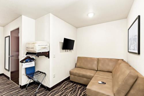 a living room with a couch and a tv at Cobblestone Hotel & Suites - Superior Duluth in Superior