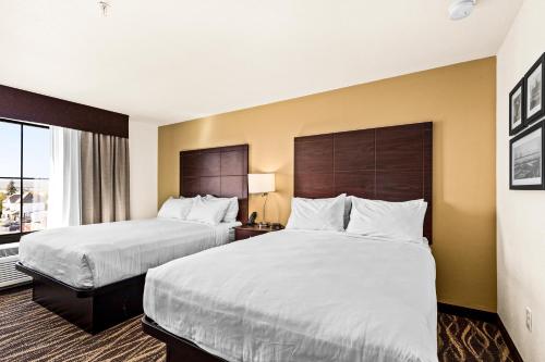 a hotel room with two beds and a window at Cobblestone Hotel & Suites - Superior Duluth in Superior