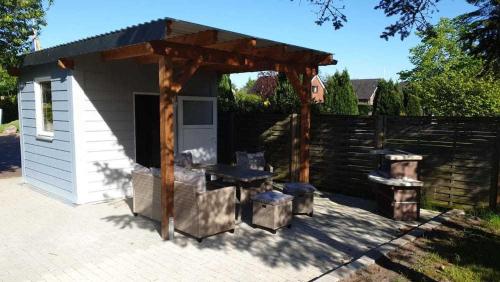 a pavilion with a picnic table and a grill at Ferienwohnungen Hachenberger in Langenhorn