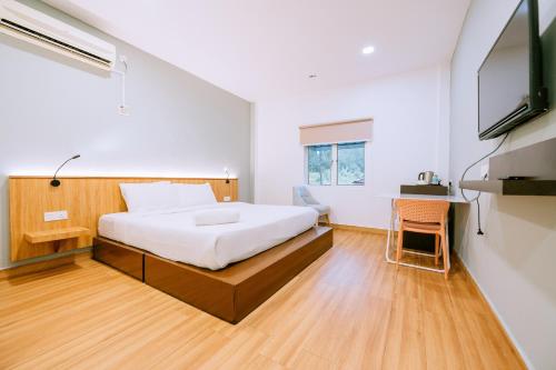 ein Schlafzimmer mit einem Bett und einem TV in der Unterkunft Chill Box Langkawi in Kuah
