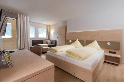 Habitación de hotel con cama y sala de estar. en Familotel Alphotel en Hirschegg