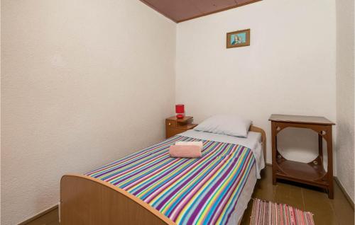 ein kleines Schlafzimmer mit einem Bett und einer Handtasche darauf in der Unterkunft 2 Bedroom Stunning Home In Susak in Susak