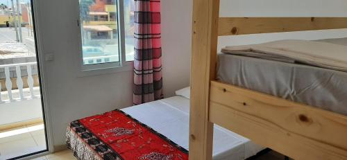 a bedroom with a bunk bed and a window at Atlantic Sal Hostel in Santa Maria