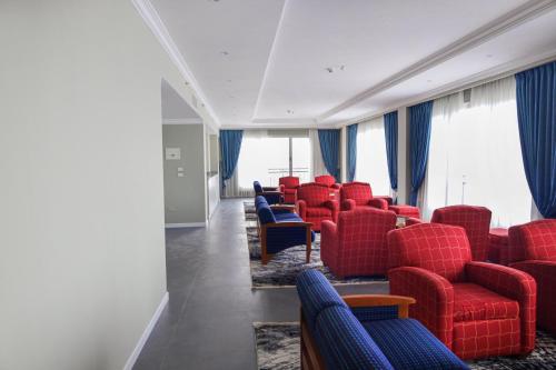 a waiting room with red chairs and blue chairs at Haile Grand Addis Ababa in Addis Ababa