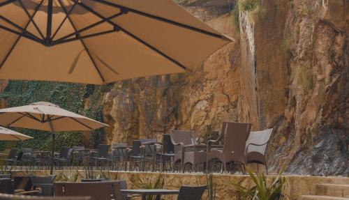a group of chairs and umbrellas in front of a rock wall at Haile Grand Addis Ababa in Addis Ababa