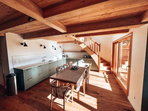 kuchnia ze stołem i krzesłami oraz schodami w obiekcie La Cabane, Superbe Duplex à 5 min des pistes w mieście Le Monêtier-les-Bains