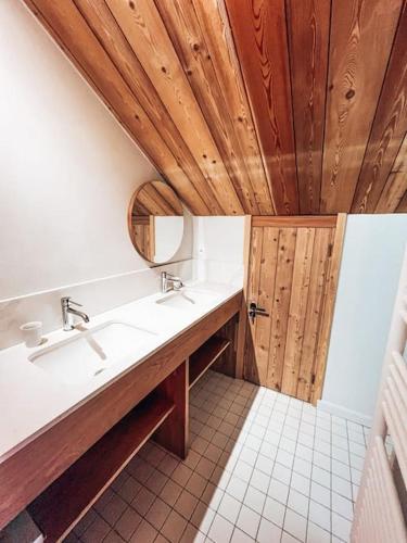 La salle de bains est pourvue de 2 lavabos et d'un plafond en bois. dans l'établissement La Cabane, Superbe Duplex à 5 min des pistes, au Monêtier-les-Bains