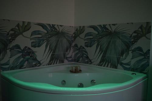 ein Badezimmer mit einer Badewanne und einer tropischen Tapete in der Unterkunft Casa Ferrera - Locazione Turistica in Misterbianco