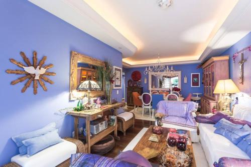 a living room with blue walls and white furniture at Morada das Flôres in Porto Alegre